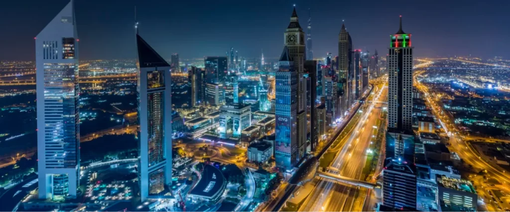 Multicultural business team, including Emirati and international professionals, engaged in a discussion during a meeting in a modern office setting.
